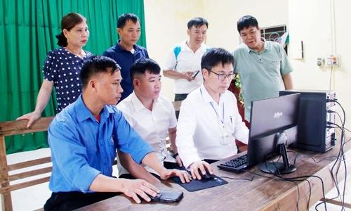 Cán bộ Trung tâm Phục vụ hành chính công xã Kiên Lao hỗ trợ người dân nộp hồ sơ trực tuyến tại nhà văn hóa thôn Đèo Cạn.
