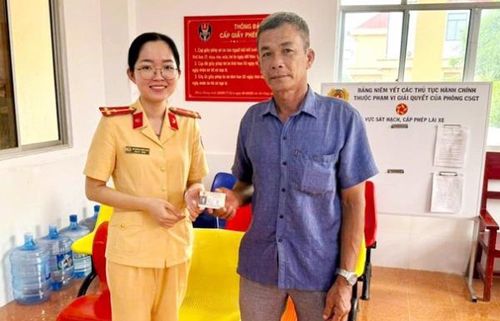 Cán bộ Phòng CSGT trả GPLX cấp đổi trong ngày cho ông Trần Văn Nam (ngụ xã Hồ Thị Kỷ, tỉnh Cà Mau). 