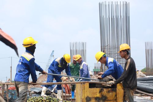 Công nhân "đội nắng" thi công các cấu kiện bằng sắt phục vụ đổ dầm trụ cầu cạn đường dẫn 2 đầu cầu của dự án.