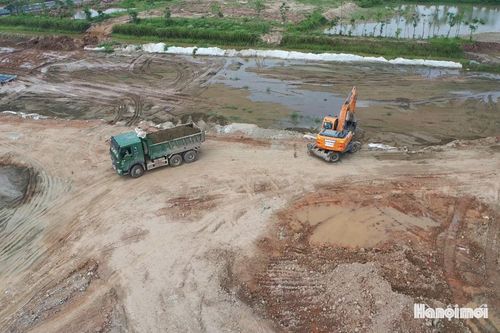 Máy móc chuyển nguyên vật liệu phục vụ thi công cầu hối hả trên công trường.