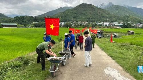 Công an xã Quang Chiểu phối hợp nhân dân địa phương dựng cờ Tổ quốc dọc tuyến đường vào xã.