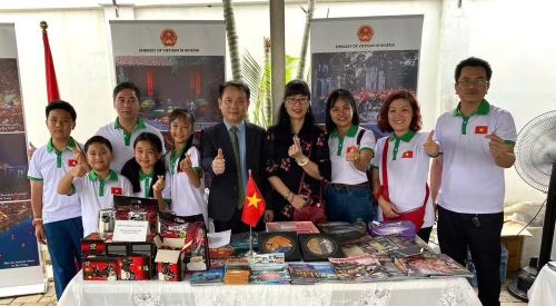 Cán bộ Đại sứ quán chụp ảnh tại gian trưng bày của Việt Nam tại hội chợ. (Ảnh do Đại sứ quán Việt Nam tại Nigeria cung cấp)