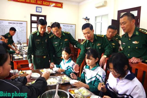 Cán bộ Bộ đội Biên phòng tỉnh Ninh Bình thăm hỏi các cháu là con nuôi đồn Biên phòng trong bữa ăn. Ảnh: Minh Khôi