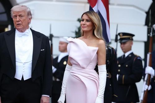 Vợ ông Trump diện váy lụa màu hồng nhạt không dây vai của Christian Dior Haute Couture, kết hợp với găng tay da lộn màu trắng ngà. Bà hoàn thiện vẻ ngoài bằng đôi giày cao gót lụa màu hoa phi yến nhạt ton-sur-ton của Dior. Cựu người mẫu trung thành với kiểu trang điểm nhẹ nhàng và để mái tóc màu mật ong buông xõa tự nhiên. Ảnh: Getty Images.