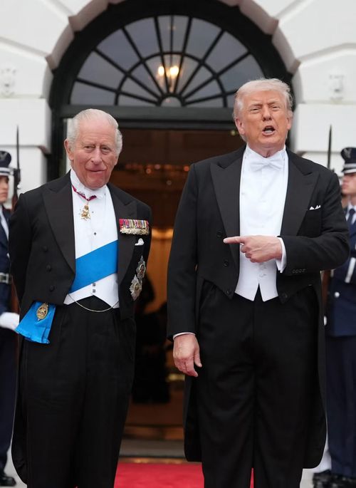 Trang phục của ông Trump và Vua Charles trông tương tự nhau, đều là lễ phục cổ điển - gồm áo đuôi tôm và quần Âu đen kết hợp áo ghi lê, sơ mi và nơ trắng. Điểm khác biệt lớn nhất là Vua Charles có dải băng xanh dương quàng chéo người và nhiều huy hiệu hoàng gia. Ảnh: AP.