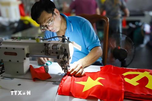 Bàn tay giữ vải, kim chỉ chuyển động nhịp nhàng, mỗi đường may là một lần “gia cố” cho sự bền bỉ của lá cờ trước nắng gió. (Ảnh: Lê Ngọc/TTXVN phát)