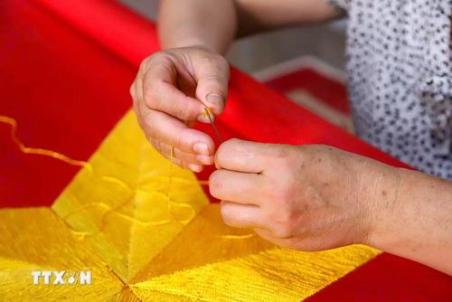 Kỹ thuật thêu cờ tay truyền thống vẫn được người dân thôn Từ Vân giữ gìn và phát triển qua bao thế hệ. (Ảnh: Lê Ngọc/TTXVN phát)