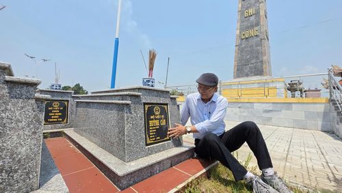Ông Hùng bên mộ của cha mình, Liệt sĩ Huỳnh Cân. Ảnh: HÀN NGUYÊN