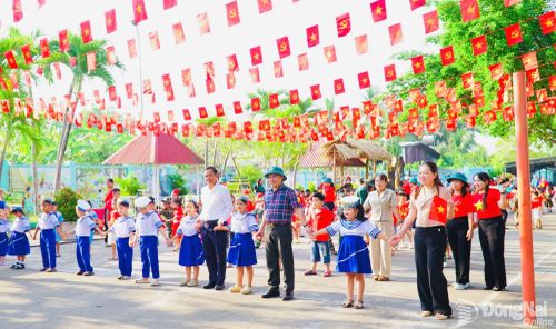 Cô và trò Trường Mầm non Phú Điền cùng đại diện địa phương tham gia hoạt động hướng về Ngày thống nhất đất nước. Ảnh: NTCC
