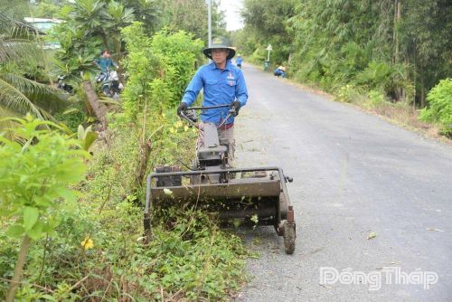 Anh Nguyễn Ngọc Thạch với máy cắt cỏ do anh chế tạo giúp việc dọn dẹp cỏ dại trên đường thuận tiện, hiệu quả hơn.