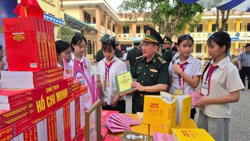 Cán bộ biên phòng giới thiệu các cuốn sách về lịch sử dân tộc và chủ quyền biên giới cho các em học sinh tại Trường PTDTBT THCS Trường Sơn - Ảnh: K.S