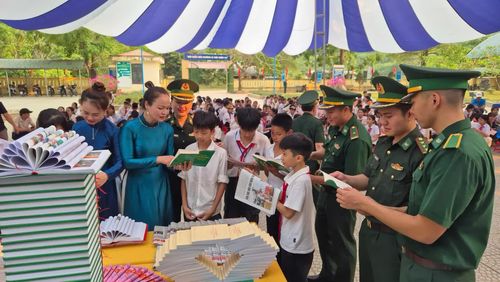 Cán bộ biên phòng giới thiệu các cuốn sách về lịch sử dân tộc và chủ quyền biên giới cho các em học sinh tại Trường PTDTBT THCS Trường Sơn - Ảnh: K.S