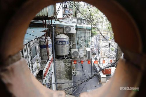 Qua ô thoáng cầu thang, những téc nước lớn hiện ra giữa hệ thống dây điện, đường ống chằng chịt.