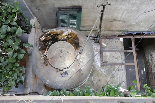 Một bồn nước cũ đặt sát mép mái, phần thân đã hoen gỉ, xuống cấp.