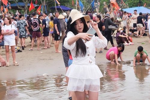  Du khách Mai Trang cố gắng check-in giữa biển người tại bãi biển Sầm Sơn chiều 30/4. Ảnh: Quỳnh Trang. 