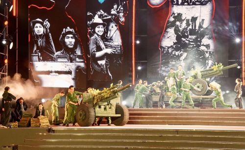 Liên khúc "Cô gái Sài Gòn đi tải đạn - Lá đỏ" do NSƯT Phạm Thế Vĩ cùng ca sỹ Thanh Nguyên, Lê Thu Hiền, My Phôn và các nhóm múa biểu diễn. Ảnh: Trung Tuyến - TTXVN