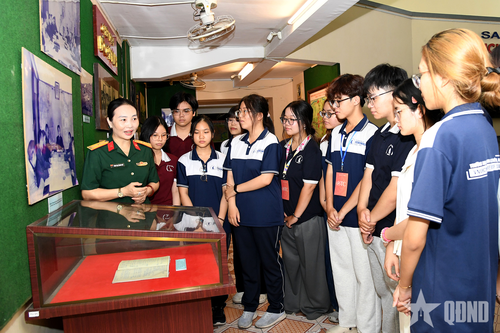  Sinh viên Trường Đại học Khoa học Tự nhiên, Đại học Quốc gia TP Hồ Chí Minh lắng nghe giới thiệu về Sổ trực ban chiến dịch Hồ Chí Minh tại Bảo tàng Chiến dịch Hồ Chí Minh. 