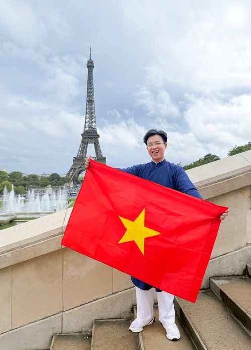 Nguyễn Quốc Trung cùng Cờ đỏ sao vàng tại Thủ đô Paris. Ảnh: NVCC