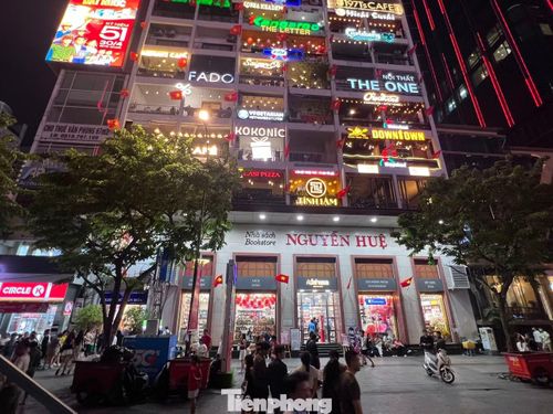 Một chung cư trang trí cờ Tổ quốc rực rỡ, nhiều du khách thích thú đứng lại chụp ảnh check-in
