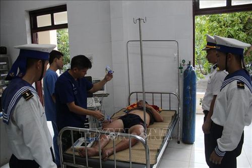 Các y, bác sĩ thăm khám cho ngư dân bị giảm áp do lặn biển. Ảnh: TTXVN phát