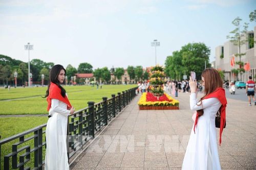 Nhiều bạn trẻ lựa chọn trang phục áo dài truyền thống khi tham quan và chụp ảnh tại khu vực Quảng trường Ba Đình, Lăng Chủ tịch Hồ Chí Minh. Ảnh: Phạm Tuấn Anh - TTXVN