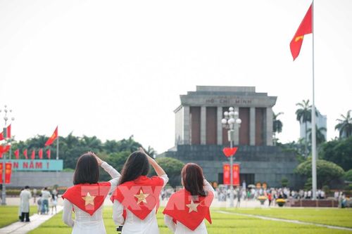 Nhiều bạn trẻ lựa chọn trang phục áo dài truyền thống khi tham quan và chụp ảnh tại khu vực Quảng trường Ba Đình, Lăng Chủ tịch Hồ Chí Minh. Ảnh: Phạm Tuấn Anh - TTXVN