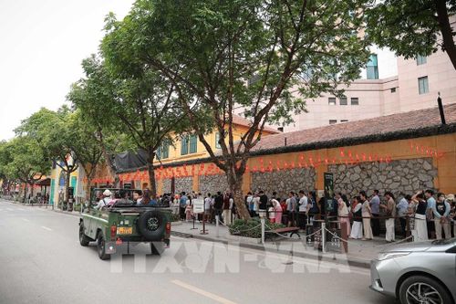 Nhiều gia đình, nhóm du khách xếp hàng dài chờ đến lượt vào tham quan di tích Nhà tù Hỏa Lò. Ảnh: Phạm Tuấn Anh - TTXVN