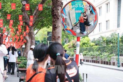 Du khách chụp ảnh lưu niệm tại khu vực check-in ngoài trời của di tích Nhà tù Hỏa Lò. Ảnh: Phạm Tuấn Anh - TTXVN
