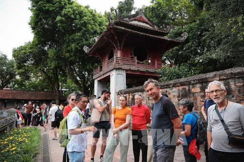 Du khách quốc tế tham quan, nghe giới thiệu về lịch sử của Văn Miếu - Quốc Tử Giám, trường đại học đầu tiên của Việt Nam. Ảnh: Phạm Tuấn Anh - TTXVN