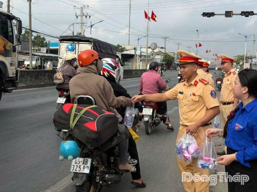 Từng chay nước trao cho người dân về quê (điểm quốc lộ 1, xã Mỹ Đức Tây)