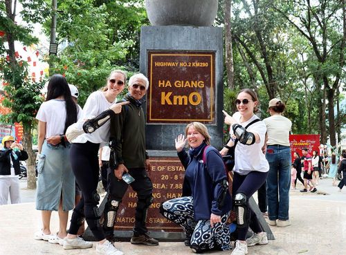 Du khách nước ngoài chụp ảnh tại biểu tượng Km 0 Hà Giang.
