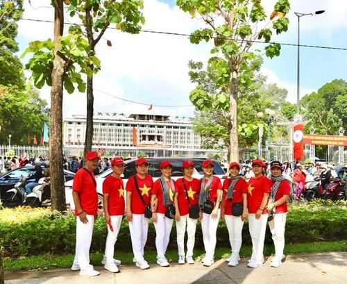 Nhiều người chọn trang phục áo cờ đỏ sao vàng, mang theo cờ Tổ quốc chụp ảnh kỷ niệm.