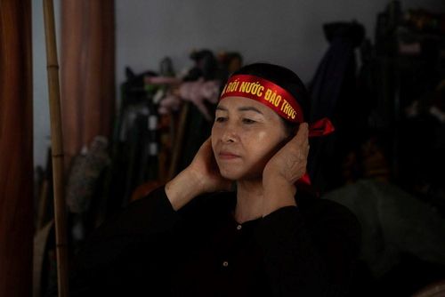 Trên trán họ, dải băng đỏ in dòng chữ “Phường múa rối nước Đào Thục” không chỉ là dấu hiệu nhận diện, mà còn như một lời khẳng định về niềm tự hào và sự gắn bó với nghề tổ