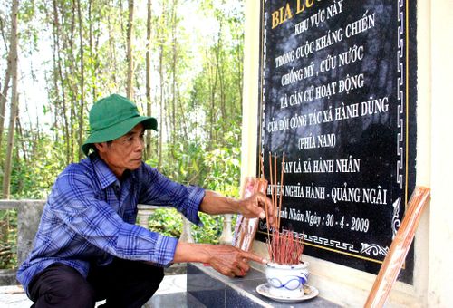Cựu chiến binh Nguyễn Văn Nam thắp hương tại bia lưu niệm, tưởng nhớ Đội Công tác xã Hành Dũng. Ảnh: NGUYỄN TRANG