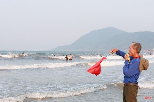 Ông Nguyễn Công Lý - Tổ cứu hộ cứu nạn, Khu du lịch Thiên Cầm thực hiện nhiệm vụ bảo đảm an toàn cho du khách tắm biển.