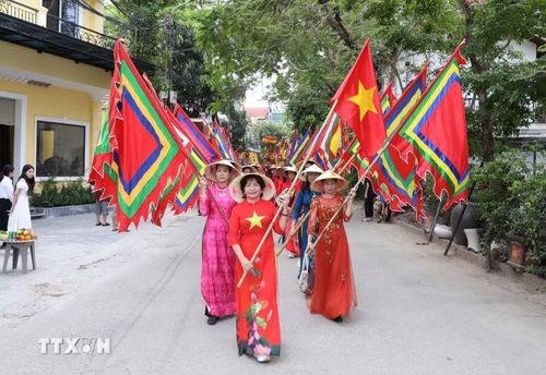 Dẫn đầu đoàn rước kiệu từ Đình Các tới Đền Thái Vi là đội hình cờ Tổ quốc và cờ hội. (Ảnh: Đức Phương/TTXVN)