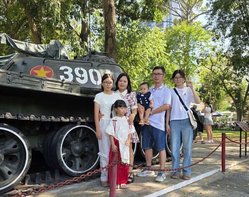Gia đình chị Minh Thu chụp ảnh kỉ niệm bên chiếc xe tăng lịch sử.
