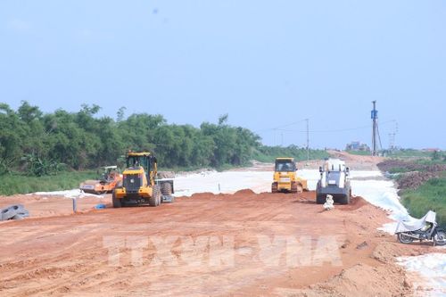 Các công nhân làm việc xuyên lễ để thi công tuyến đường kết nối di sản dọc sông Hồng. Ảnh: Đinh Văn Nhiều-TTXVN 