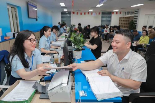 Người dân hào hứng khi Thành phố đã chính thức triển khai tiếp nhận thủ tục hành chính phi địa giới với 100% thủ tục, giúp tiết kiệm thời gian và tạo thuận lợi trong quá trình giải quyết hồ sơ. Ảnh: Phan Phương – TTXVN