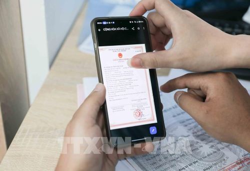Cán bộ Chi nhánh số 6 Trung tâm Phục vụ hành chính công Hà Nội tại Việt Hưng tận tình hỗ trợ người dân nộp hồ sơ trực tuyến, xóa bỏ rào cản địa giới. Giải pháp giúp tiết kiệm thời gian, chi phí và tạo thuận lợi tối đa cho người dân. Ảnh: Phan Phương – TTXVN