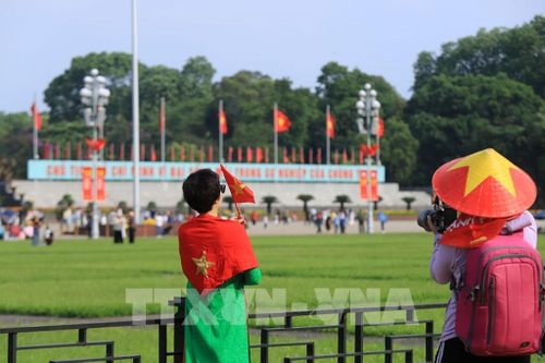 Người dân "check-in" với lá Quốc kỳ để thể hiện tinh thần yêu nước. Ảnh: Tuấn Anh - TTXVN