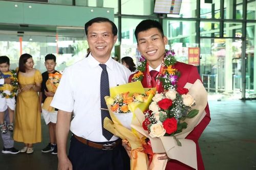 Trần Minh Hậu (phải) trong ngày trở về từ SEA Games 32, bên cạnh ông Trần Duy Linh - Giám đốc Trung tâm Võ thuật cổ truyền Bình Định. Ảnh: Hoàng Quân