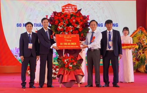 Đồng chí Hoàng Xuân Tân, Phó Chủ tịch UBND tỉnh tặng hoa và quà cho Trường THPT Lê Hồng Phong - Ảnh: N.H