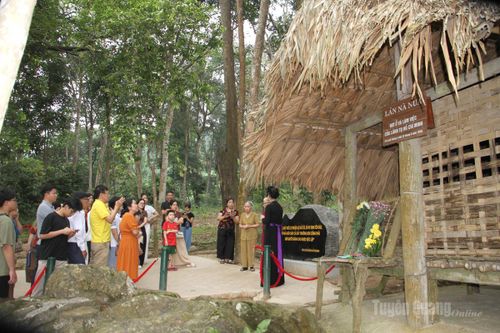 Đoàn khách tham quan Lán Nà Nưa, lắng nghe câu chuyện về Bác và những quyết định lịch sử của dân tộc chính tại ngôi lán nhỏ này.