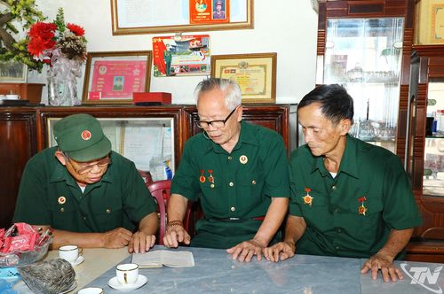Cuốn nhật ký viết lại những kỷ niệm thời quân ngũ của ông Đỗ Anh Tuấn. Trong ảnh lần lượt từ phải sang trái: Ông Trần Duy Minh, ông Đỗ Anh Tuấn và ông Ngô Hồng Mưu.