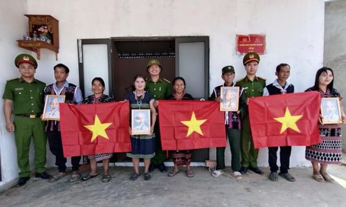 Tuổi trẻ Công an xã Avương trao cờ Tổ quốc và ảnh Bác Hồ tặng người dân làng Atêếp.