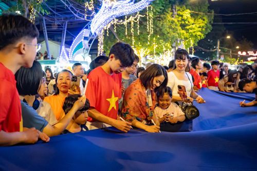 Nhân dân và du khách cùng nhau viết những ước nguyện của mình lên tấm vải chàm.