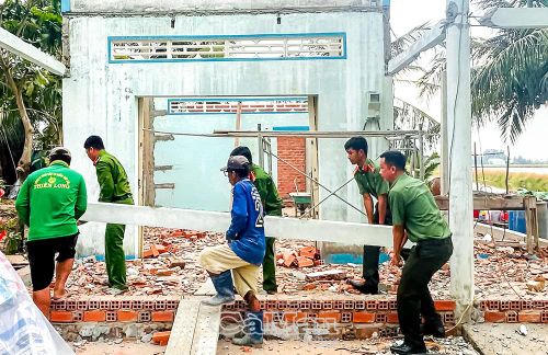 Đoàn viên, thanh niên công an hỗ trợ tháo dỡ nhà cũ để xây dựng nhà mới cho gia đình ông Trần Văn Lĩnh (ấp Bần Ổi, xã Vĩnh Lộc).