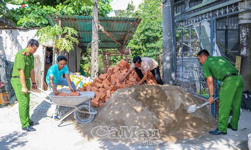 Cán bộ, chiến sĩ Công an phường Vĩnh Trạch hỗ trợ vận chuyển vật tư xây dựng nhà cho gia đình ông Kiều Thanh Sang (khóm Vĩnh An).