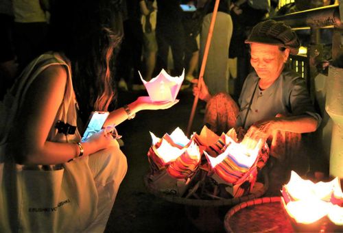 Du khách tham gia thả hoa đăng trên sông Hoài. Ảnh: Tấn Thành.
